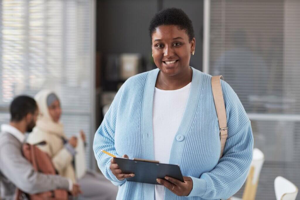 Happy Young Woman In Quiet Luxury Attire Standing Blog Size