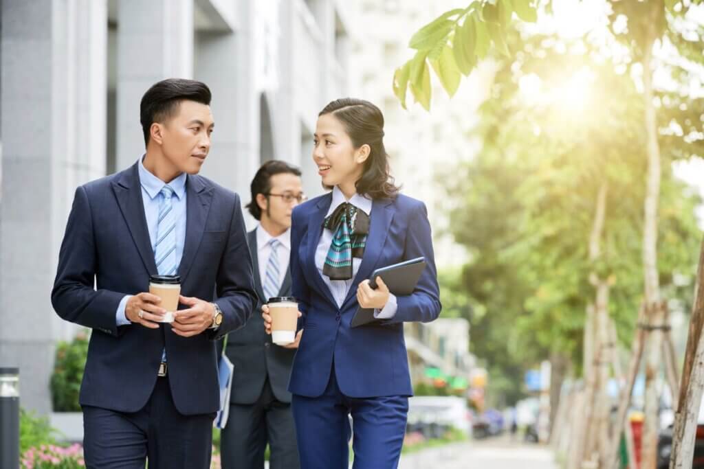 Stylish Asian Businesspeople With Coffee Walking